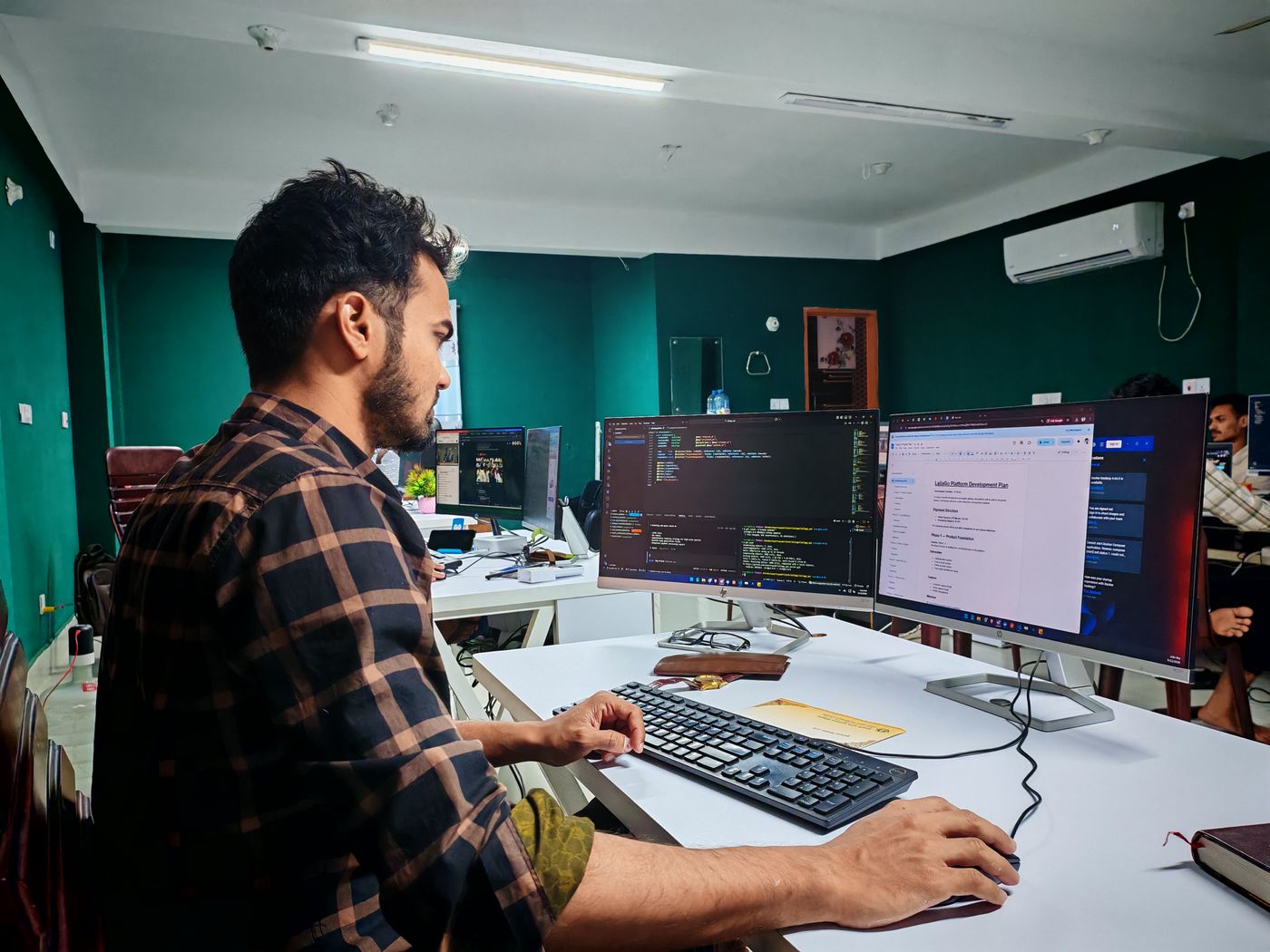 Software engineer building a web platform across multiple monitors